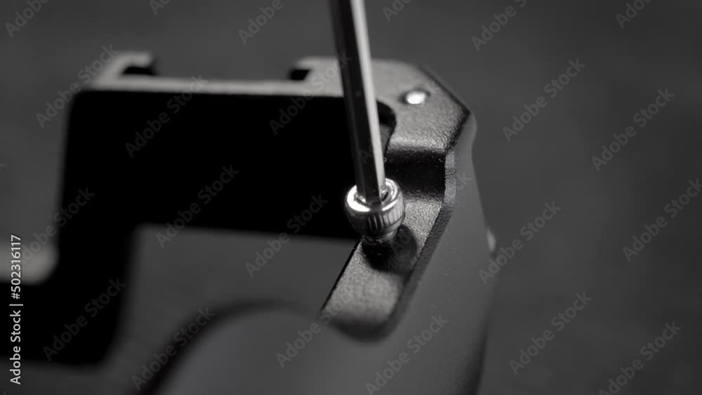 Unscrewing metal black hardware with allen key and screw close up. Using hex key. Hexagonal wrench. Macro Unscrewing metal black hardware with allen key and screw close up. Using hex key. Hexagonal wrench. Macro