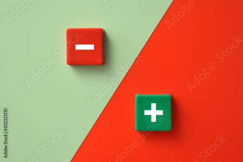 Plus and minus signs on a multi-colored background. Positive and negative information