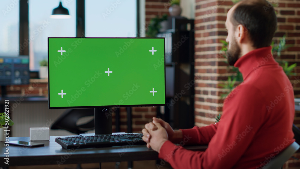 Male employee working with green screen on monitor, using technology at desk. Office worker analyzing blank copyspace with isolated mockup template and chroma key background on computer. Male employee working with green screen on monitor, using technology at desk. Office worker analyzing blank copyspace with isolated mockup template and chroma key background on computer.