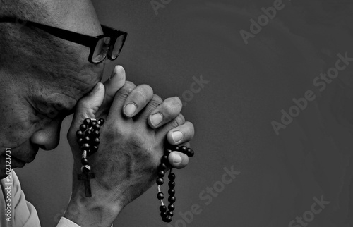 man praying to God with hands together stock photo