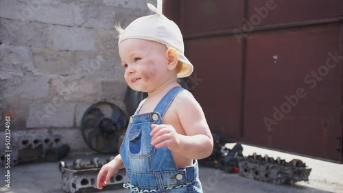 baby mechanic looks away and smiles, then turns to camera