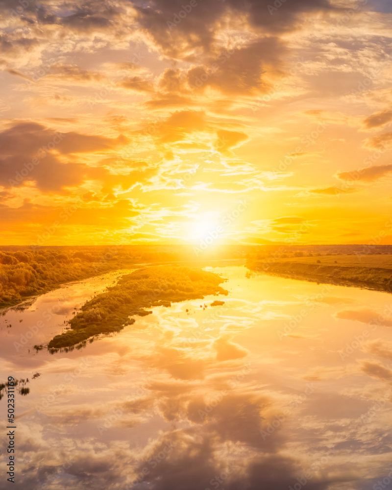 A sunset or sunrise a river with cloudy skies reflecting in the water.