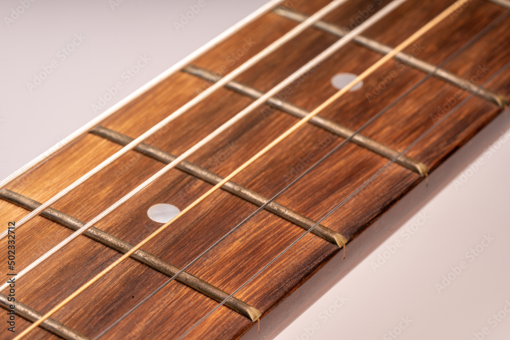 Selective focus, close up guitar neck and guitar strings on white background. Selective focus, close up guitar neck and guitar strings on white background.