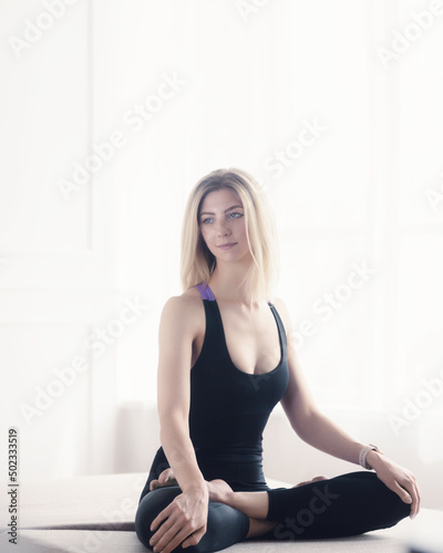 Attractive young woman doing yoga stretching at home