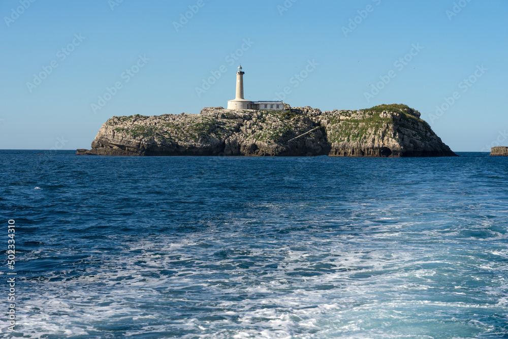 Wake of a touristic ferry in the Santander bay with the Mouro island in the background, North of Spain.