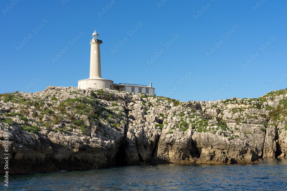 Mouro island lighthouse with blue sky in the background, North of Spain.