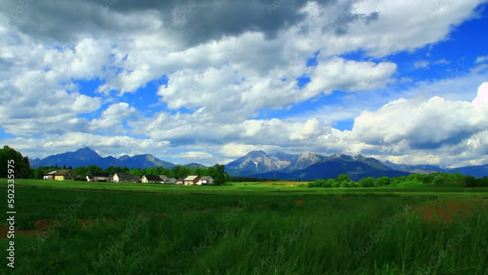 Small village near forests, mountains and intensive clouds move on the sky. Small village near forests, mountains and intensive clouds move on the sky.