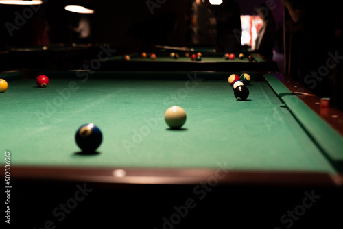 Pool table. Balls on the pool table during the match. Party game with a drill at the bar.