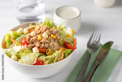 Close up of tuna salad bowl with different lettuce and vegetables on the restaurant table