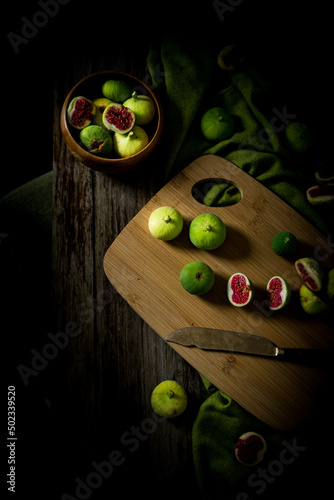 Autumn came with its charming, healthy fruits. Green ripe figs on a wooden background. 