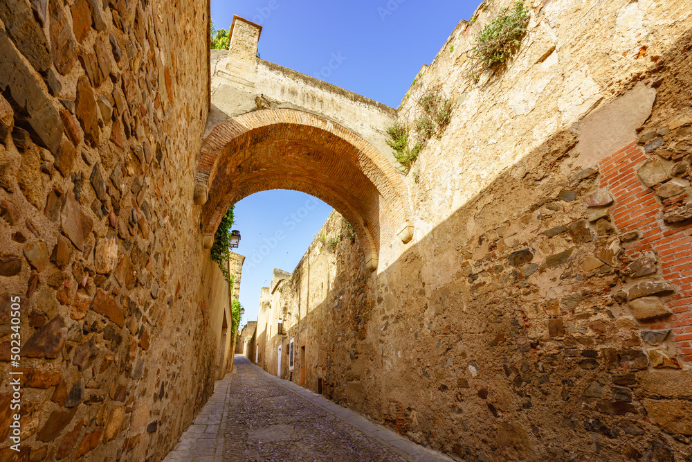 Narrow street in Caceres old town by city wall known as Adarve (Walkway)