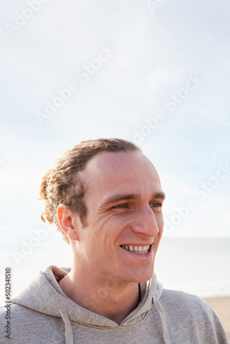 young man smiling happy with sky in the background