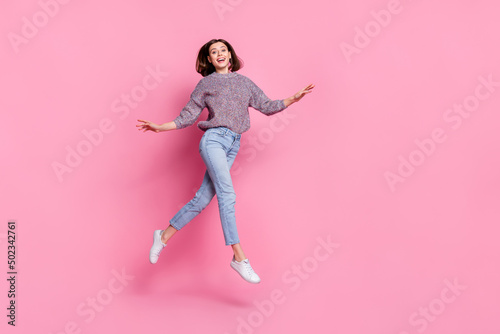 Photo of sweet excited woman wear pullover walking running jumping empty space isolated pink color background
