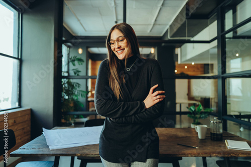 Happy young businesswoman smiling cheerfully in a modern office photo