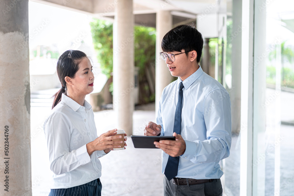 Young business partner using tablet to talking about business project Young business partner using tablet to talking about business project