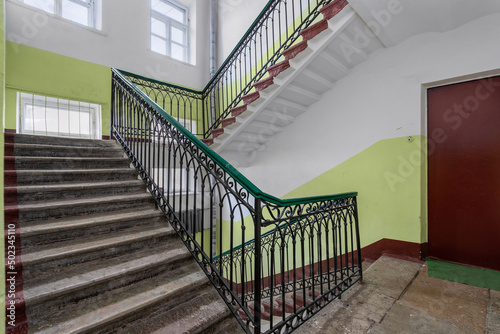 Public staircase in the old house of the city of St. Petersburg on a sunny day