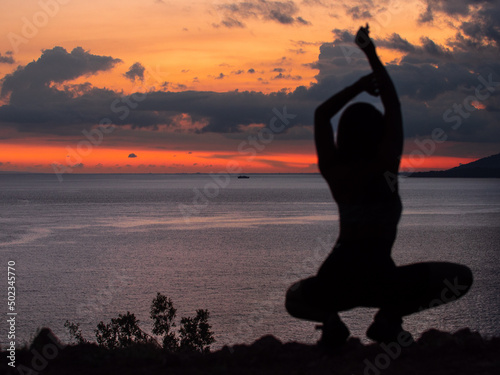 Fototapeta Naklejka Na Ścianę i Meble -  A girl posing during a sunset with ocean