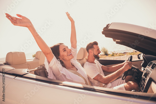 Profile side view portrait of attractive adorable carefree cheerful couple riding car having fun free time outdoors