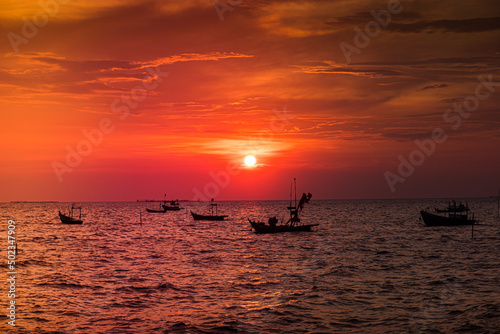 Silhouette of sunset time with fishing Long tail boats (Traditional boats) on the sea sunset silhouette background orange sky 