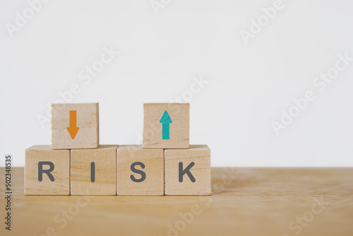 Fototapeta Naklejka Na Ścianę i Meble -  risk word on wooden cube blocks under arrow up and down for business strategy , business risk management concept