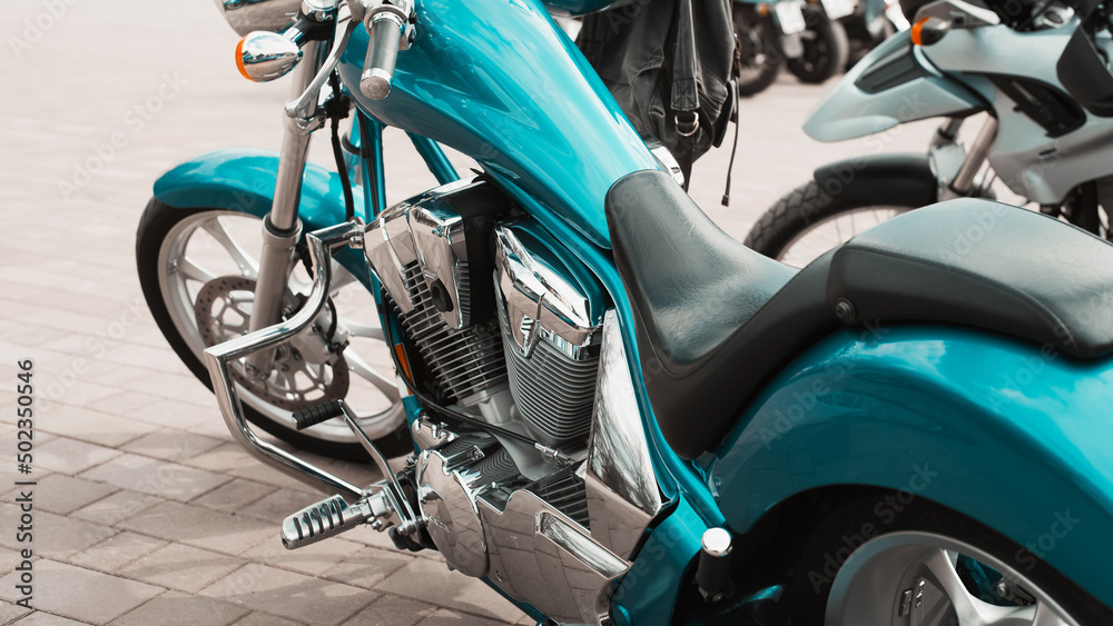 Cyan chrome stylish bike parked outdoors. Close-up of custom motorcycle with shiny details Cyan chrome stylish bike parked outdoors. Close-up of custom motorcycle with shiny details