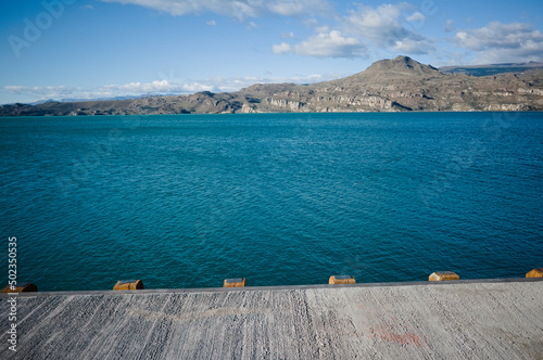 View of mountains from pier on Lake Lago General Carrera, Puerto Ibanez, Aysen Province, Chile. Summer day at glacial lake with clear bright blue water and light ripples on water in Chilean Patagonia photo