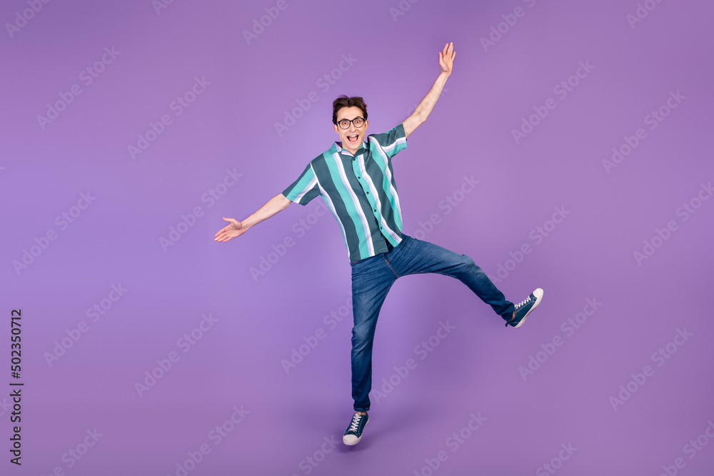 Fototapeta premium Full size photo of young man jump up fooling playful have fun wear casual clothes isolated over violet color background