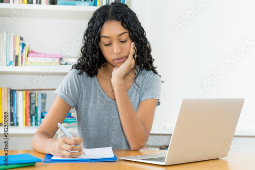 Pretty south american female student learning at desk