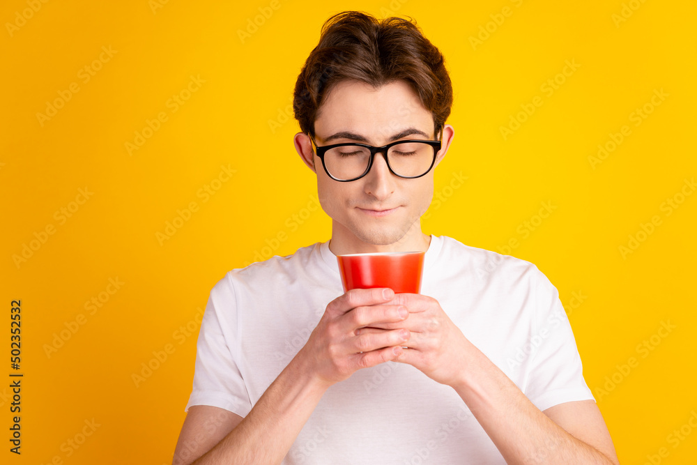 Photo of young handsome guy enjoy morning latte americano cup break isolated over yellow color background Photo of young handsome guy enjoy morning latte americano cup break isolated over yellow color background
