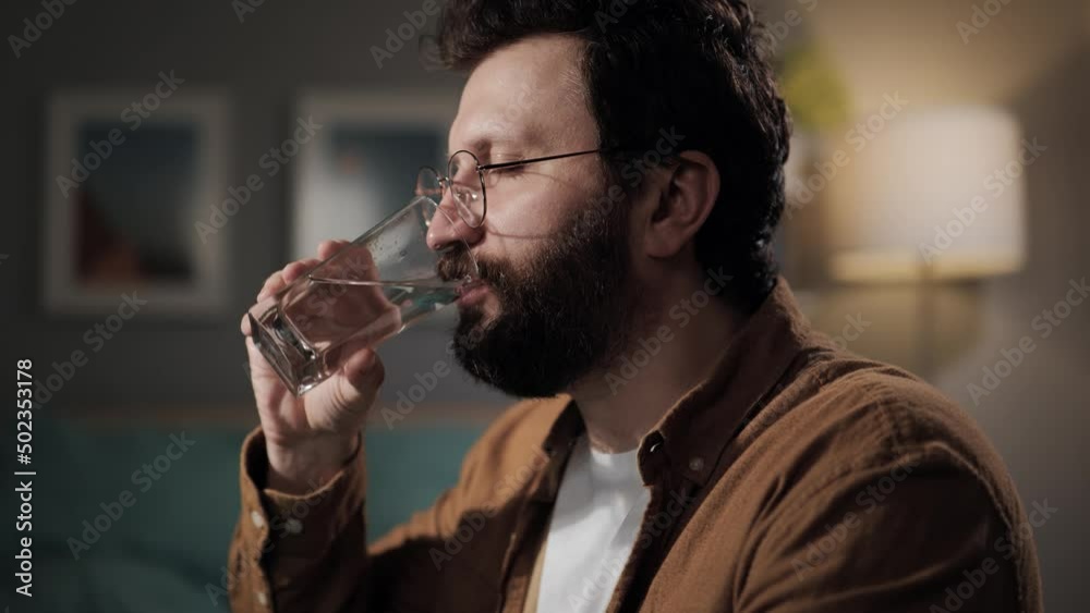 Drinking water. Handsome bearded man drinks water. Happy millennial quenches his thirst Drinking water. Handsome bearded man drinks water. Happy millennial quenches his thirst