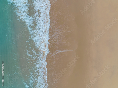Foto Aerial top view to tropical sandy beach and blue ocean