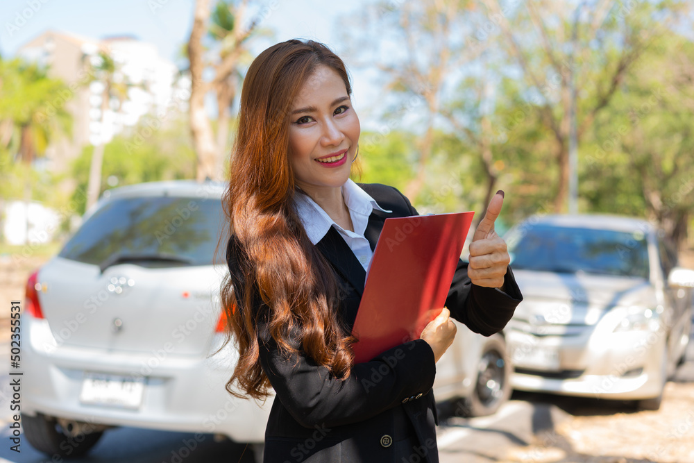 Fototapeta premium Asian women are insurance agents holding clipboards and standing in front of car accidents after checking car damage, Concepts of insurance, and car traffic accidents.