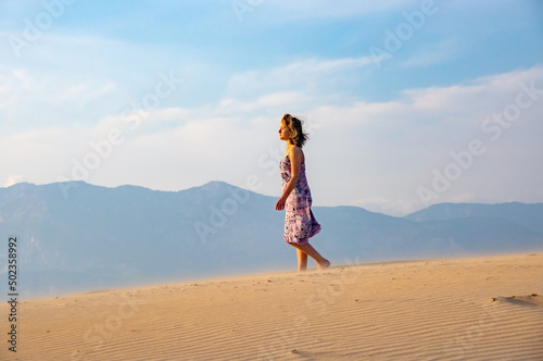 Freedom and happiness. Along young woman on sand enjoying sun, nature