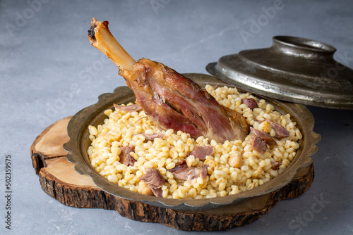 Turkish foods; lamb shank tandoori on bulgur wheat rice (Turkish name; bulgur bugday pilavi kuzu incik tandir) photo