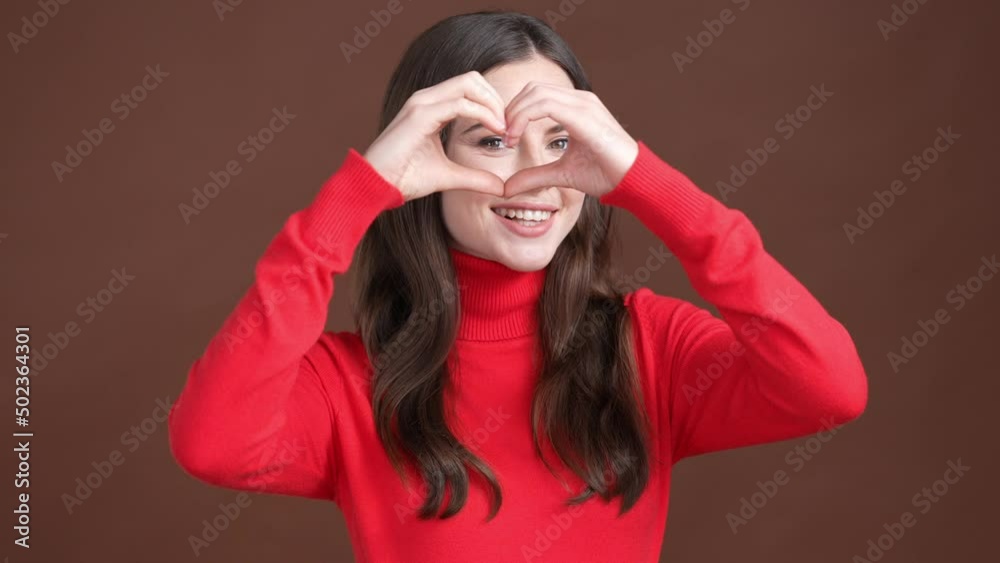 Lovely girl send air kiss heart like symbol isolated brown color background