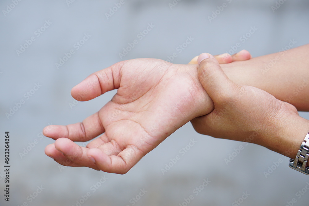 Woman holding her wrist pain from using computer, office syndrome Woman holding her wrist pain from using computer, office syndrome