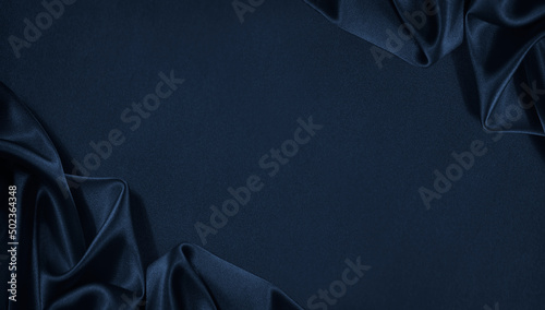 Beautiful dark blue silk satin background. Soft folds on shiny fabric. Luxury background with space for design. Web banner. Flat lay, Table top view. Christmas, Valentine's Day. photo