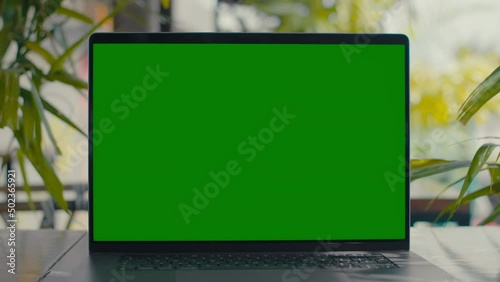 Green Screen laptop on table with green plants on background