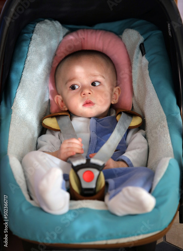 Un bébé attaché dans son siège voiture