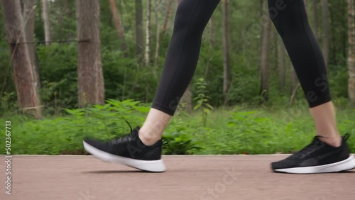The girl runs and makes a stop. The legs of a running girl.