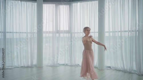 The ballerina dances in the hall with flowers.