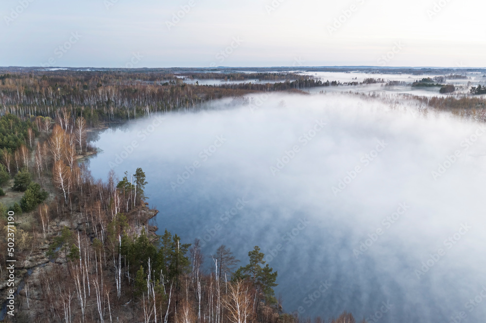 A huge lake is slightly covered with fog