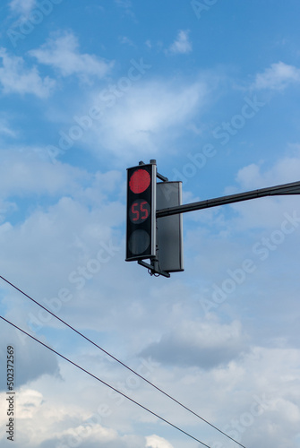 Red light on the semaphore against the cloudy blue sky