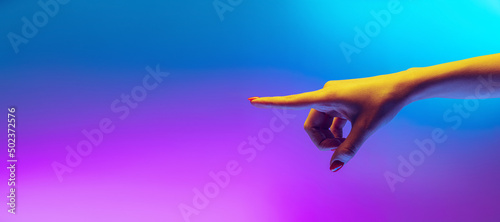 Studio shot of aethentic human hand isolated on gradient purple-blue background in neon light. Concept of human relation, community, togetherness