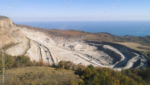 Top view of sand quarry with excavators. Shot. Open pit mining operations with operating excavators. Mining industry concept