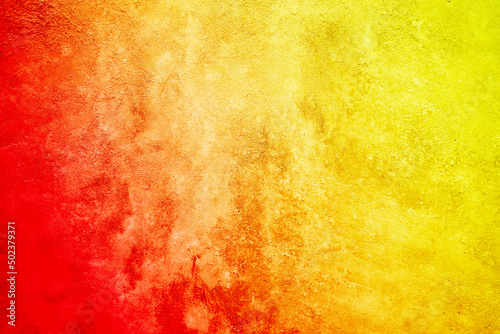 Bright abstract yellow orange red background. Toned rough surface texture. Colorful background with space for design.