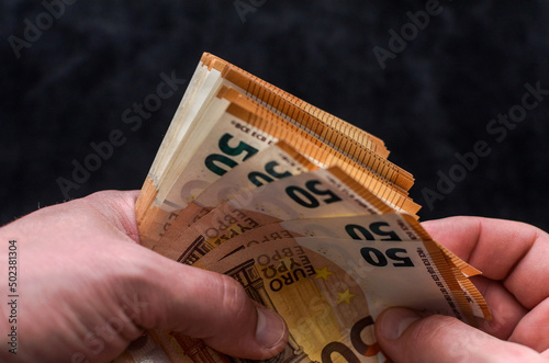 A man counts money - euro banknotes with a face value of 50 euros 