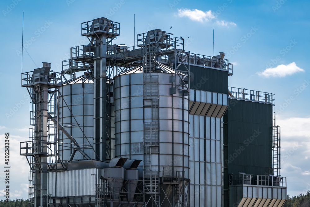 panorama view on agro silos granary elevator on agro-processing manufacturing plant for processing drying cleaning and storage of agricultural products, flour, cereals and grain.
