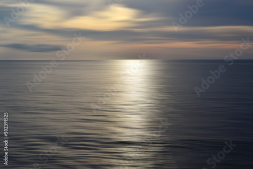 Blurry ocean landscape background and sunset view in digital motion effect.