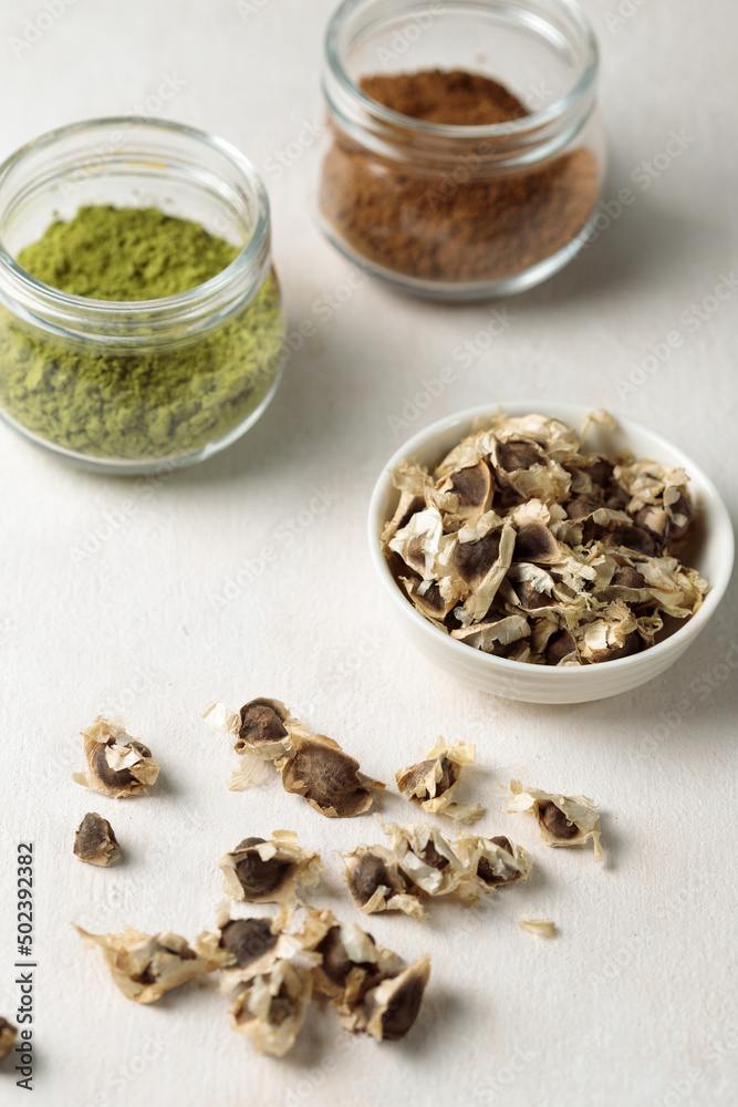 Pile of Moringa seed and moringa flower with leaf isolated on white background. The dried seeds in the pod are ready for propagate. Natural herbs can be extracted into oil for healthcare. Pile of Moringa seed and moringa flower with leaf isolated on white background. The dried seeds in the pod are ready for propagate. Natural herbs can be extracted into oil for healthcare.